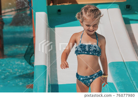 happy little girl splashing around in the pool happy little girl splashing around in the pool 76877980