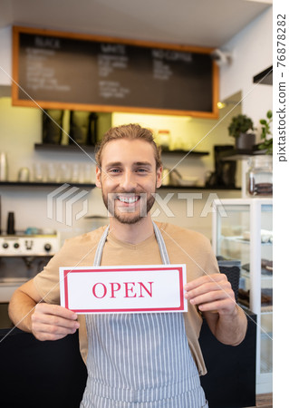 Happy optimistic man holding sign Open in cafe Happy optimistic man holding sign Open in cafe 76878282