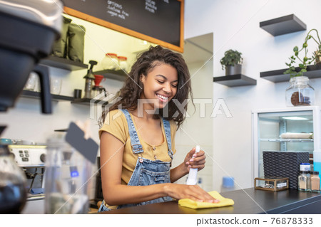 Involved laughing woman wiping the bar counter Involved laughing woman wiping the bar counter 76878333