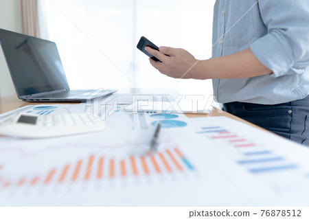Businessman in casual wear stands beside desk to work at home with sma Businessman in casual wear stands beside desk to work at home with sma 76878512