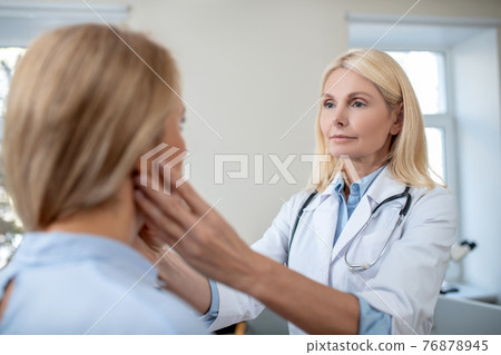 Doctor touching patients neck with his hands 76878945