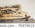 A thorn crown with nails and Holy Bible on a wooden table over the light background.  76879618
