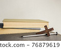 A cross with nail with bible over a light background.  76879619