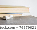 An earphone with books over the light background. 76879621
