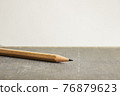 A sharp pencil over book with a light background.  76879623