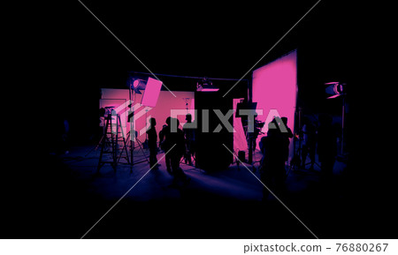 Silhouette images of film production. behind the scenes or b-roll of making video commercial movie. Film crew lightman and cameraman working together with film director in studio. Film industry. 76880267