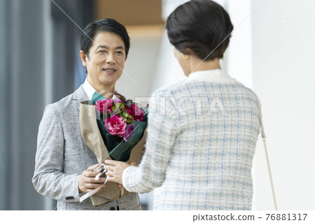 Image of a middle-aged couple presenting a bouquet Image of a middle-aged couple presenting a bouquet 76881317