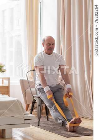 Man sitting on chair doing paschimottanasana or Intense Dorsal Stretch pose Man sitting on chair doing paschimottanasana or Intense Dorsal Stretch pose 76882264