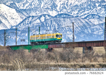 以春天的北阿爾卑斯山為背景,穿越長願寺川鐵橋的黃色列車 富山千穗鐵道的風景 以春天的北阿爾卑斯山為背景,穿越長願寺川鐵橋的黃色列車 富山千穗鐵道的風景 76882624