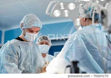 Team surgeon at work in operating room. 76884270