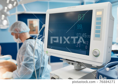 Anesthesiologist keeping track of vital functions of the body during cardiac surgery. Surgeon looking at medical monitor during surgery. Doctor checking monitor for patient health status. Anesthesiologist keeping track of vital functions of the body during cardiac surgery. Surgeon looking at medical monitor during surgery. Doctor checking monitor for patient health status. 76884271