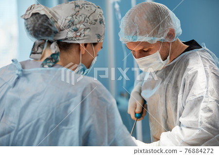 Team surgeon at work in operating room. Team surgeon at work in operating room. 76884272