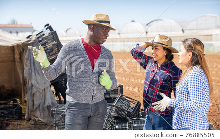 Farmer talking to female workers 76885505