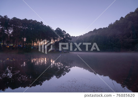 Fog or mist on river lake with forest trees in Pang Ung reservoir, Mae Hong Son, Thailand. Tourist attraction, surrounded by green pine, mountains, reflection from water. 76885620