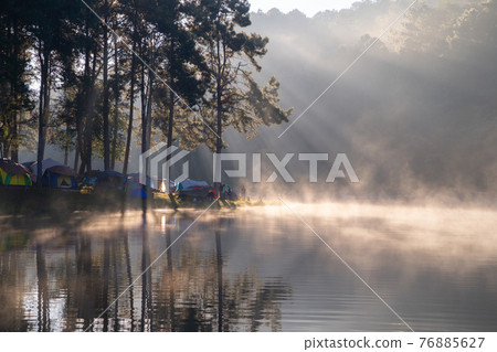 Fog or mist on river lake with forest trees in Pang Ung reservoir, Mae Hong Son, Thailand. Tourist attraction, surrounded by green pine, mountains, reflection from water. 76885627
