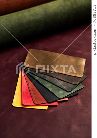 Artificial leather samples on a cow leather background. Top view. 76885715