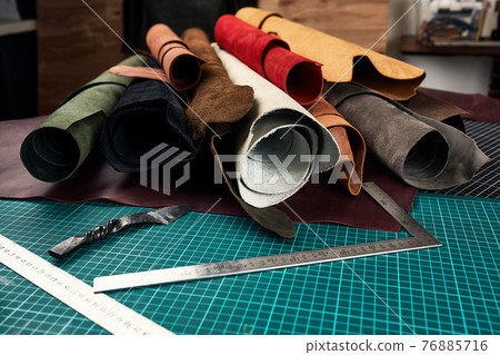 Artificial leather samples on a cow leather background. Top view. 76885716