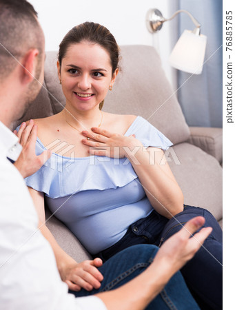 Couple is playful talking on the sofa Couple is playful talking on the sofa 76885785