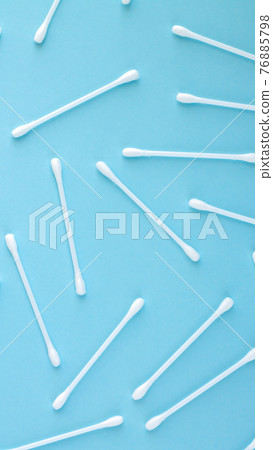 Pattern of white plastic cotton swabs top view on blue background Pattern of white plastic cotton swabs top view on blue background 76885798