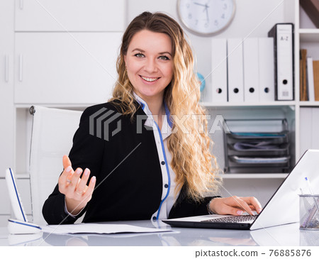 Smiling woman working in the office Smiling woman working in the office 76885876