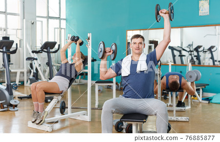 Man resting between workouts in gym Man resting between workouts in gym 76885877