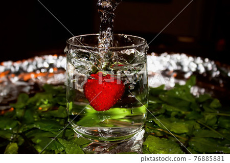 Stawberry with water splash in front of mint leaves. Stawberry with water splash in front of mint leaves. 76885881