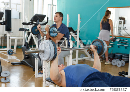 Sporty man practicing bench press Sporty man practicing bench press 76885887