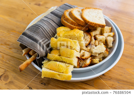 Italian bread, croutons, grissini on plate 76886504