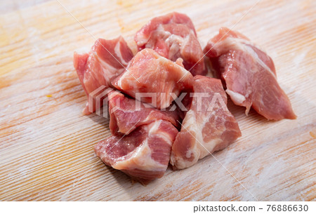 Close up of fresh raw pork slices on wooden surface Close up of fresh raw pork slices on wooden surface 76886630