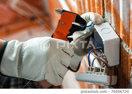 Electrician at work on a residential electrical system. Electricity. Electrician at work on a residential electrical system. Electricity. 76886720