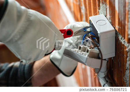 Electrician at work on a residential electrical system. Electricity. 76886721