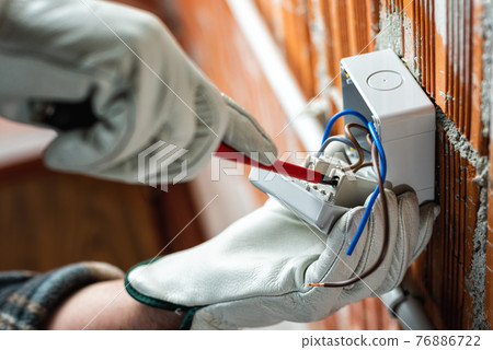 Electrician at work on a residential electrical system. Electricity. Electrician at work on a residential electrical system. Electricity. 76886722