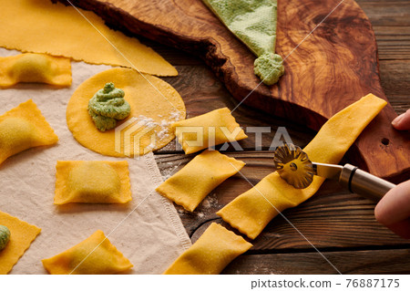 Raw homemade ravioli pasta with spinach and ricotta 76887175