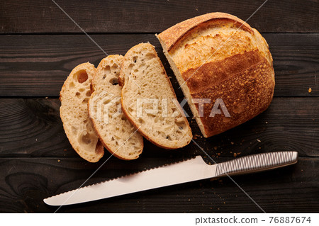 Homemade tartine bread on dark wooden table Homemade tartine bread on dark wooden table 76887674