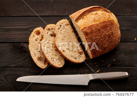 Homemade tartine bread on dark wooden table Homemade tartine bread on dark wooden table 76887677
