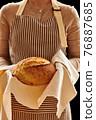 Baker holding loaf of homemade bread 76887685