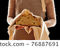 Baker holding loaf of homemade bread 76887691