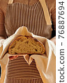 Baker holding loaf of homemade bread 76887694