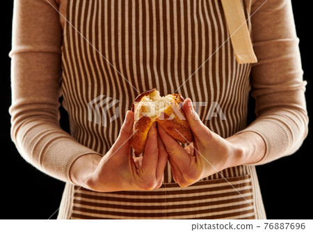 Baker holding homemade bun 76887696