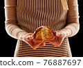 Baker holding homemade bun 76887697