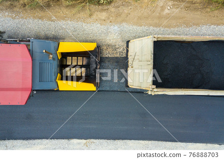 Aerial view of new road construction with asphalt laying machinery at work. 76888703