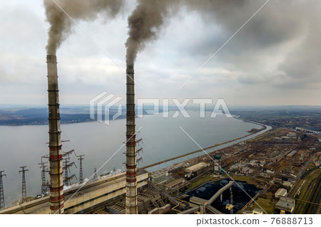 Aerial view of coal power plant high pipes with black smoke moving up polluting atmosphere. Aerial view of coal power plant high pipes with black smoke moving up polluting atmosphere. 76888713