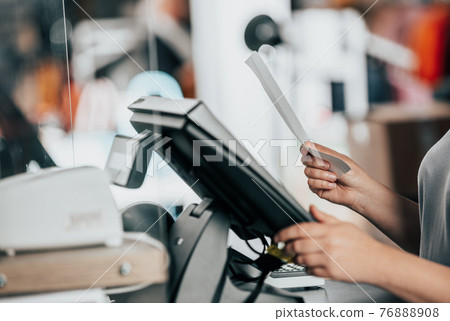 Young woman doing process payment with the bill or invoice on the POS cash terminal in the shop, finance concept Young woman doing process payment with the bill or invoice on the POS cash terminal in the shop, finance concept 76888908