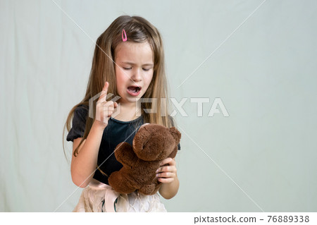 Pretty child girl playing with her teddy bear toy. Pretty child girl playing with her teddy bear toy. 76889338