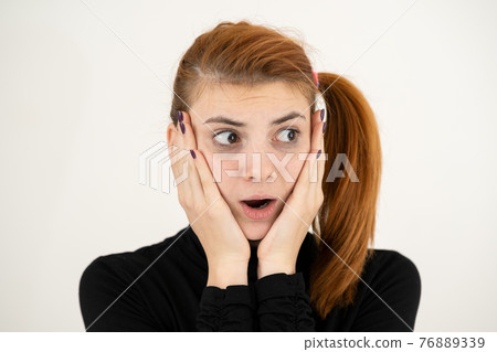 Portrait of serious young woman holding her hands to face thinking concentrated about something. Portrait of serious young woman holding her hands to face thinking concentrated about something. 76889339