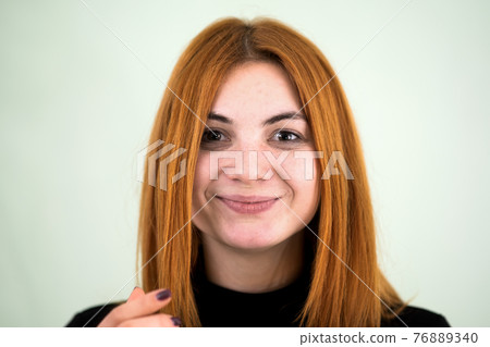 Closeup portrait of a funny redhead teenage girl with childish hairstyle isolated on white backround. Closeup portrait of a funny redhead teenage girl with childish hairstyle isolated on white backround. 76889340