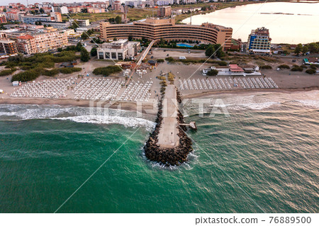 Aerial view of Pomorie city that is located on Black Sea shore. Top view of sand beaches with many hotel buildings and tourist infrastructure. Aerial view of Pomorie city that is located on Black Sea shore. Top view of sand beaches with many hotel buildings and tourist infrastructure. 76889500
