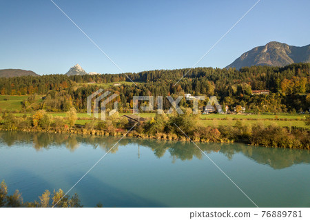 Aerial view of green meadows with villages and forest in austrian Alps mountains. 76889781