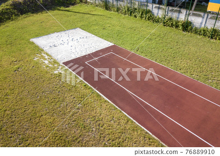 Top view of red running tracks and green grass lawn. Infrastructure for sports activities. Top view of red running tracks and green grass lawn. Infrastructure for sports activities. 76889910