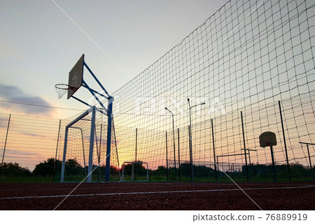 Outdoors mini football and basketball court with ball gate and basket surrounded with high protective fence. Outdoors mini football and basketball court with ball gate and basket surrounded with high protective fence. 76889919